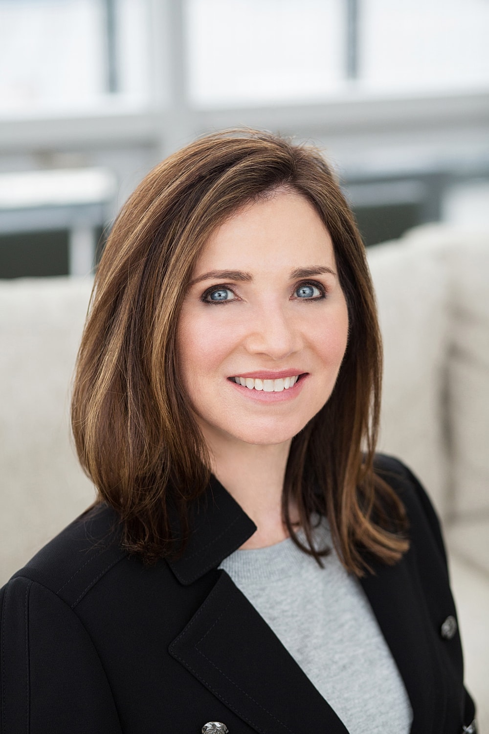 Professional woman smiling in modern office setting.
