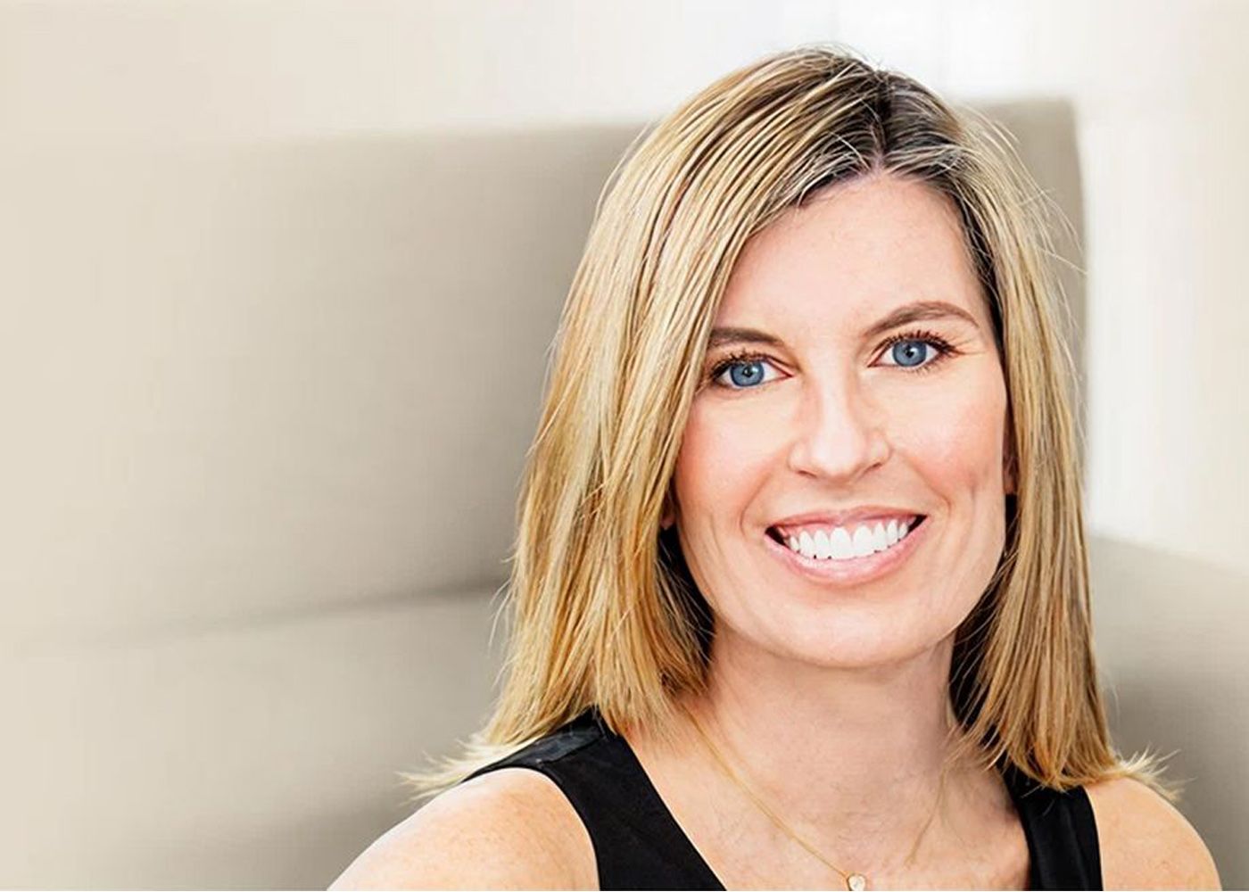 Smiling woman with blonde hair and blue eyes.