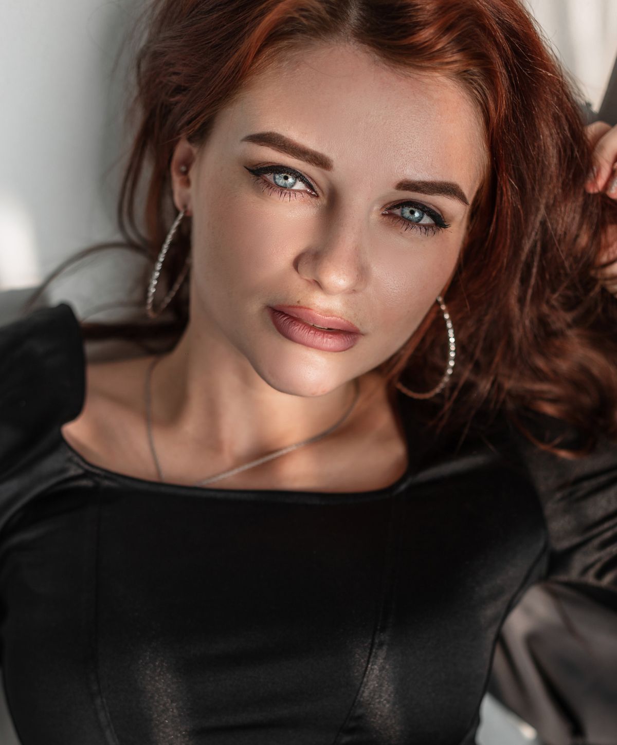 Woman with blue eyes and auburn hair, close-up.