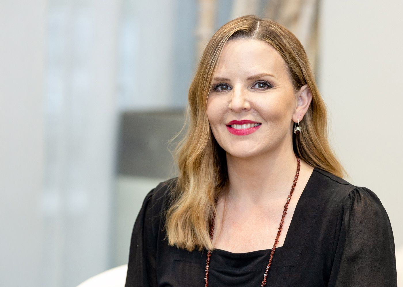 Smiling woman with long hair and black top.
