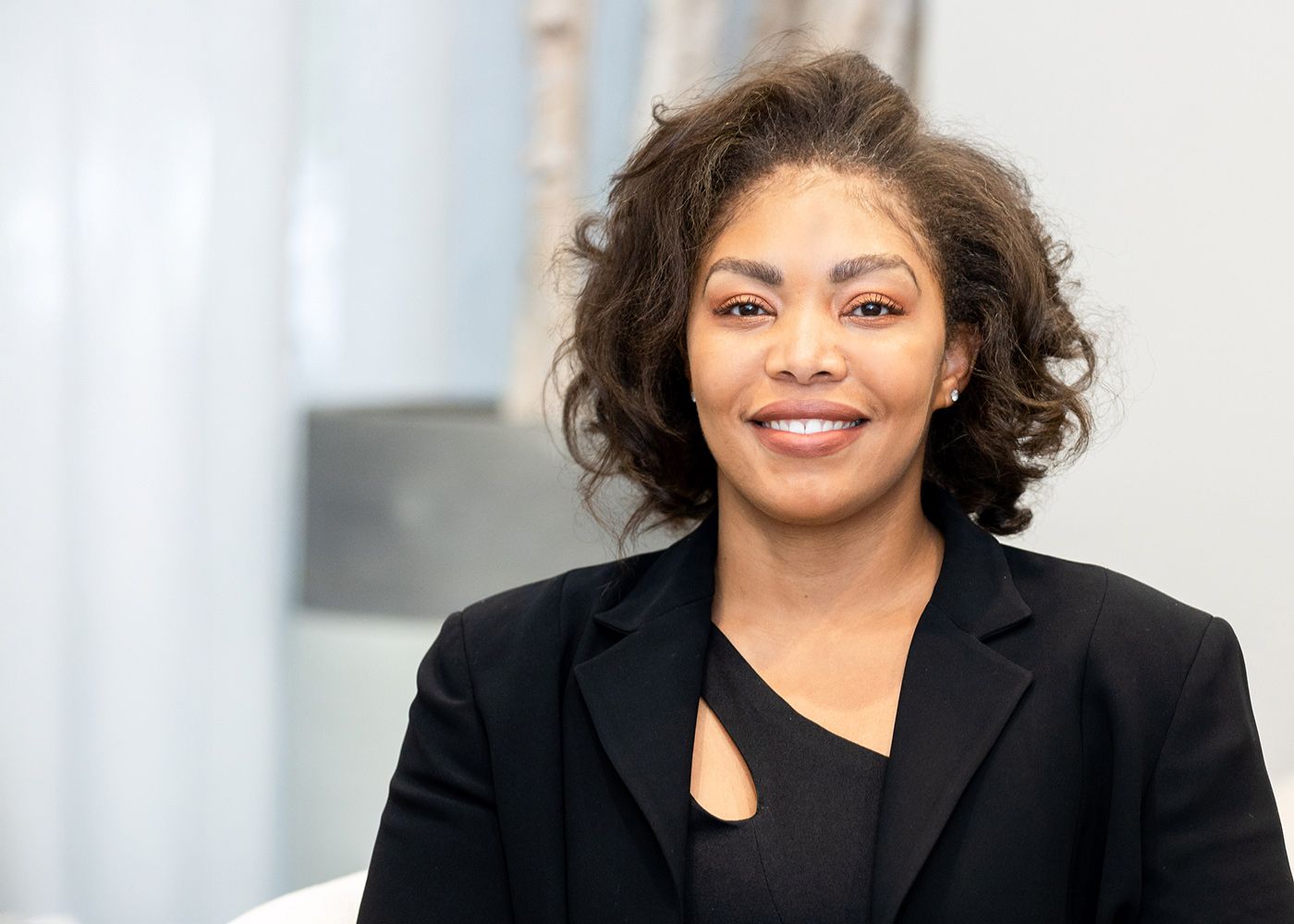 Smiling woman in black blazer portrait.
