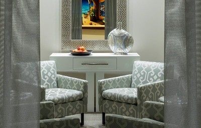 Cozy sitting area with patterned chairs and decor.