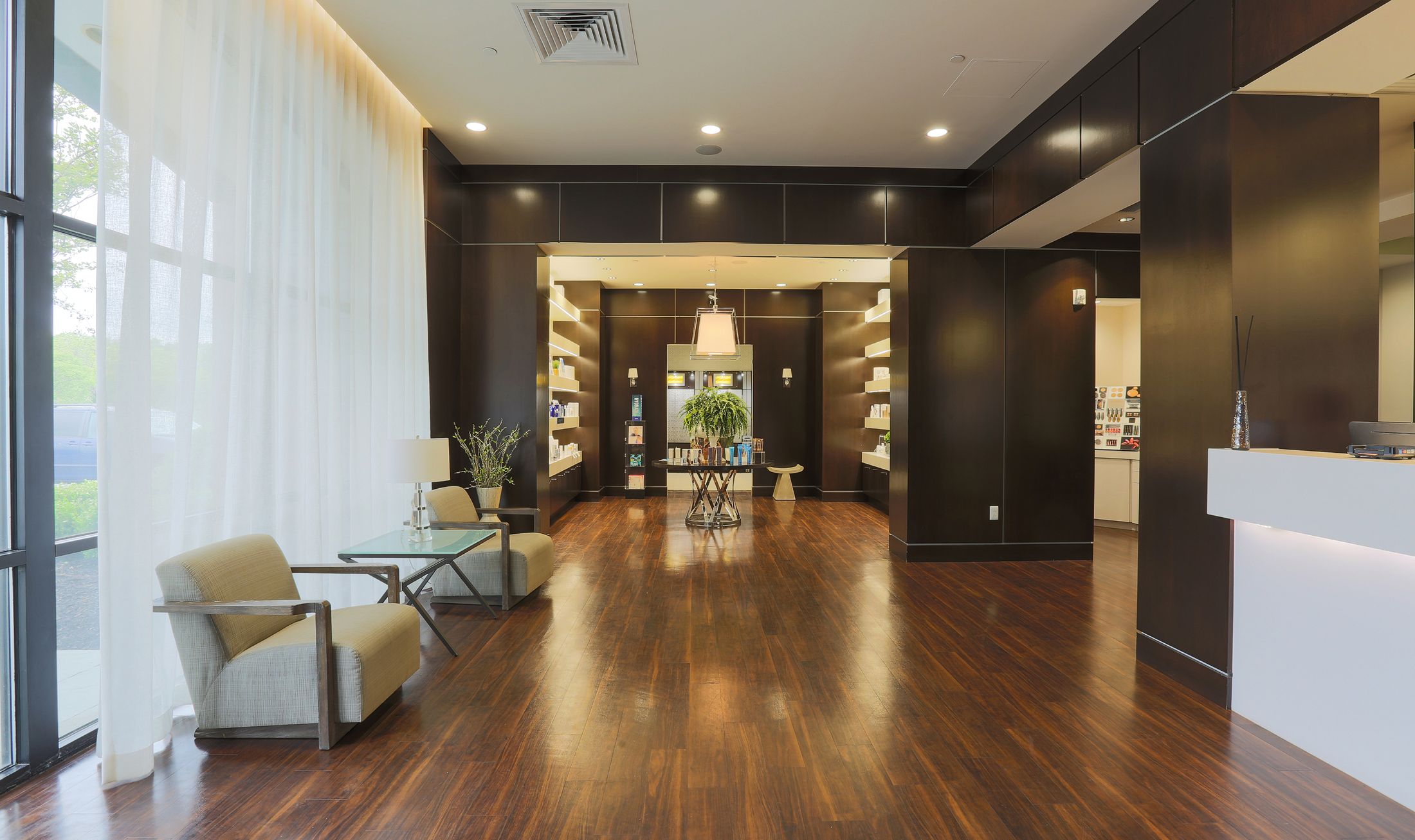Modern reception area with wooden floors and shelves.