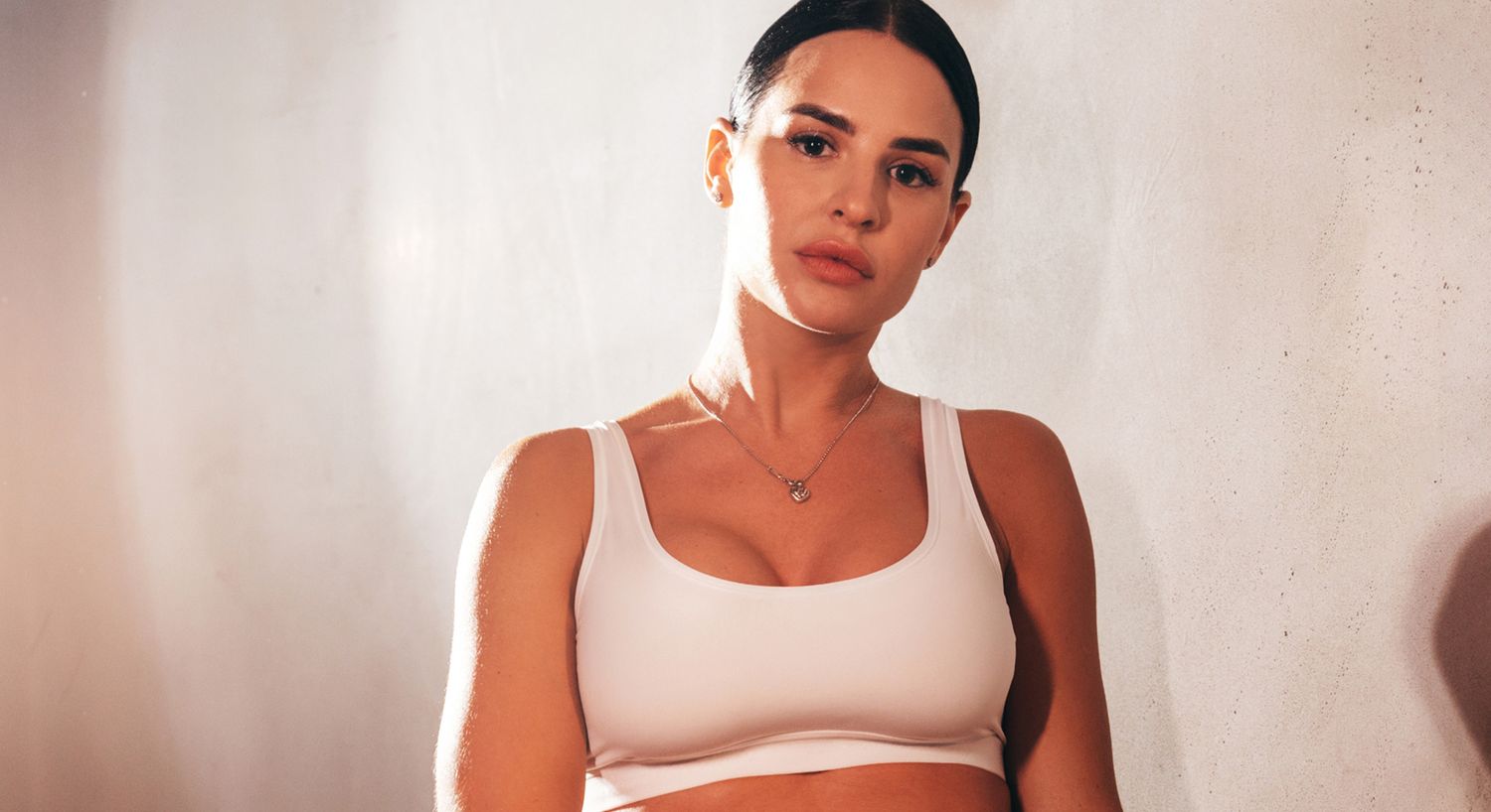 Woman posing in a white sports bra.