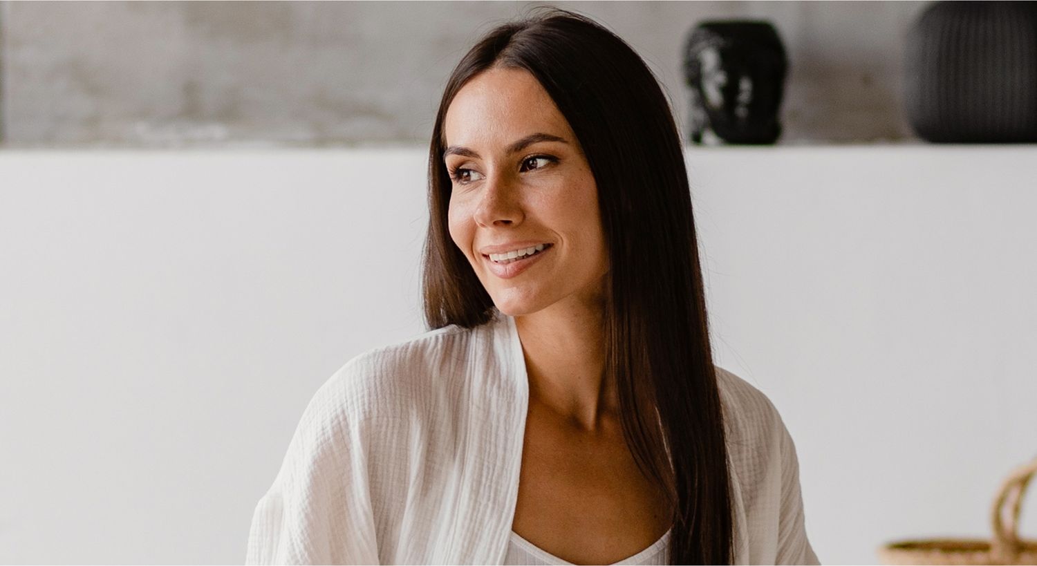 Smiling woman with long hair in bright space.