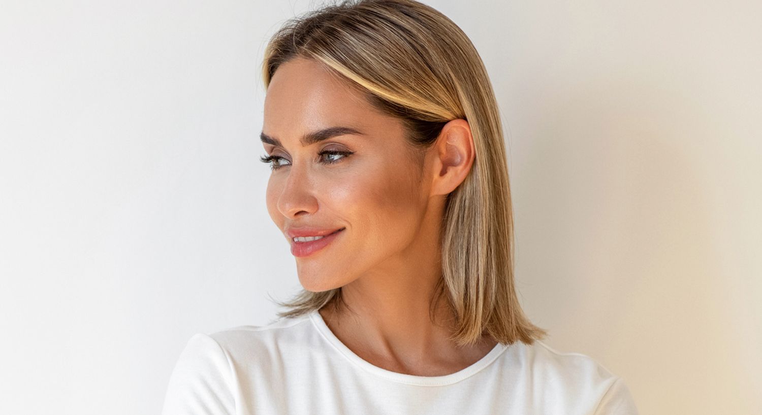 Smiling woman with short hair against light background.