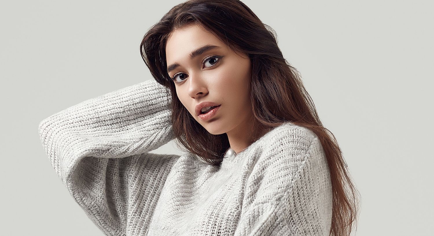 Model posing in a cozy gray sweater.