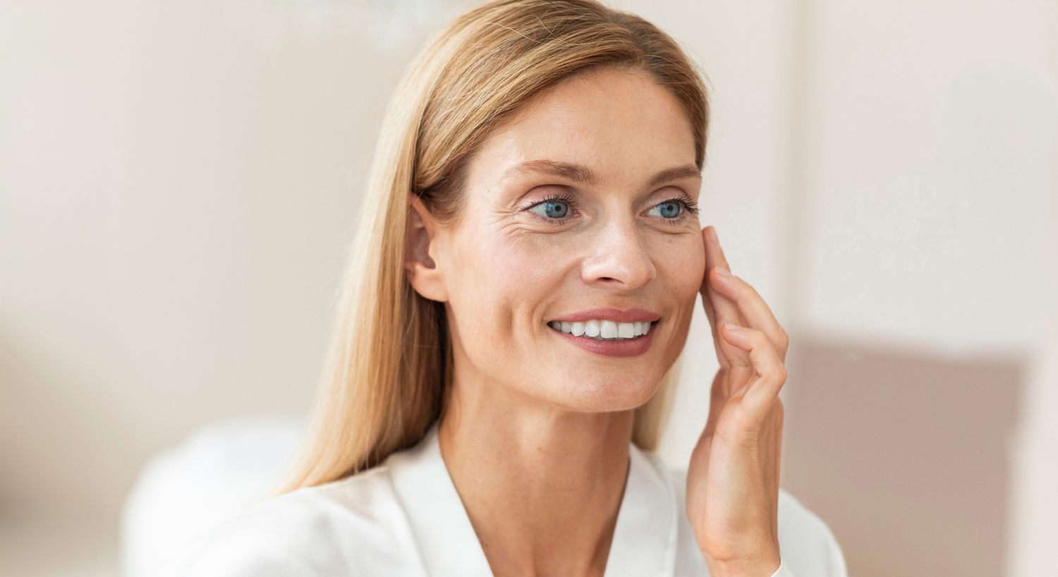 Smiling woman touching her face, skincare routine.