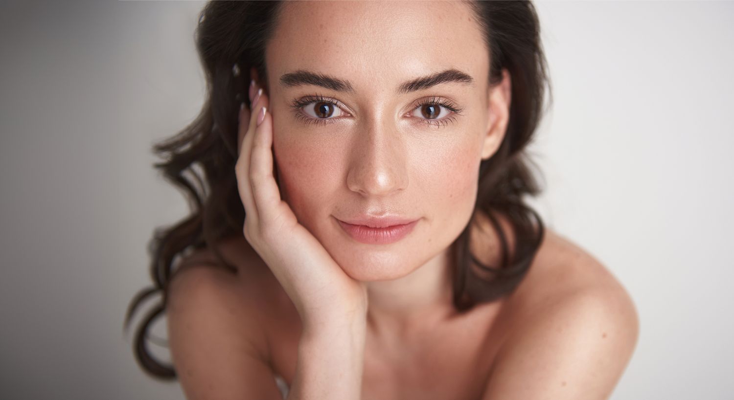 Young woman with natural makeup, resting her face.