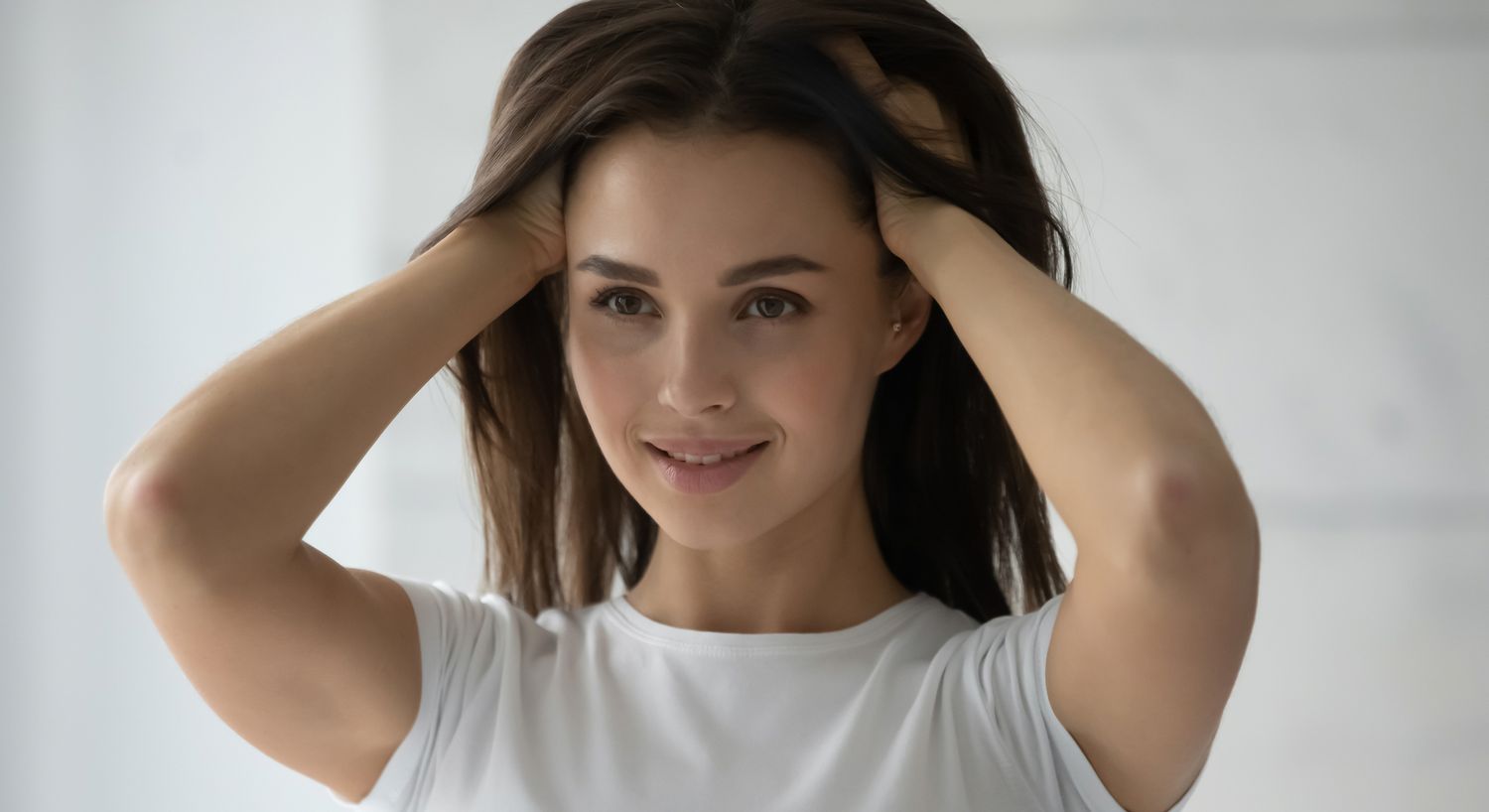 Smiling woman with hands in her hair